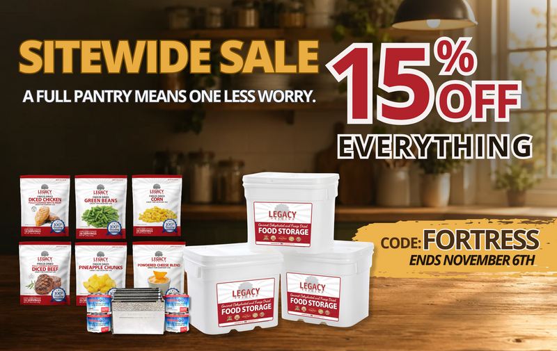 Promotional advertisement for a sitewide sale of Legacy Food Storage products, showing white plastic food storage containers and bags of grain and canned goods on a wooden table in a kitchen setting, with large text offering 15% off everything.